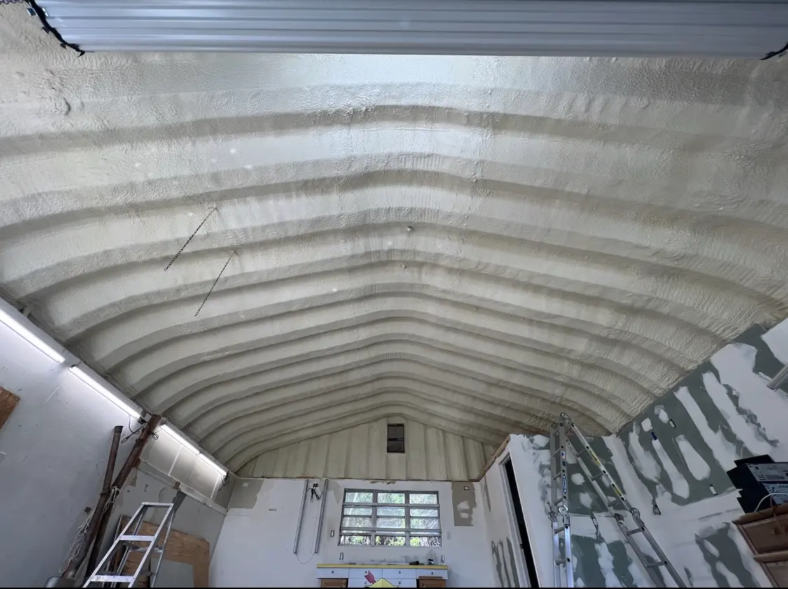 Spray polyurethane foam applied to the underside of a metal roof deck in Commerce